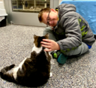 Austin petting a cat during Book Buddies