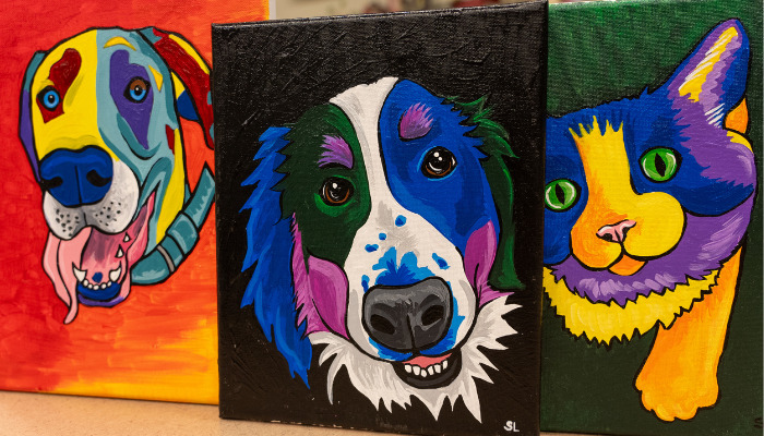 Painted pictures of a cat and two dogs in pop art style.